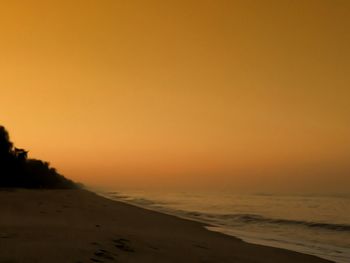 Scenic view of sea against orange sky