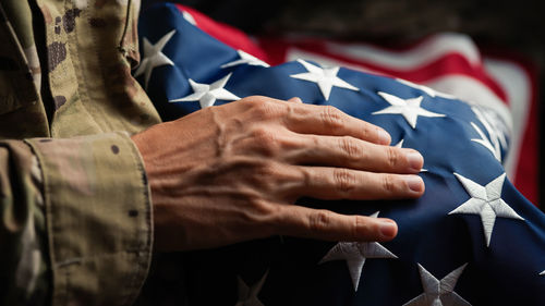 Usa soldier caressing a united states flag on veterans day