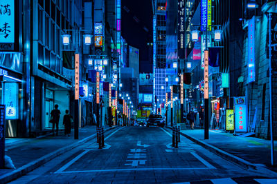 People walking on city street at night