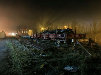 Train on railroad tracks against sky at night