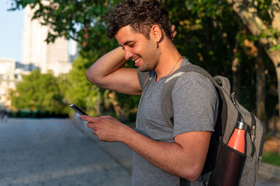 Young man using mobile phone while standing outdoors