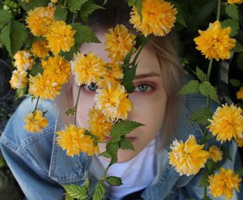 Close-up of woman with yellow flowers
