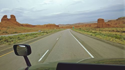 Road passing through landscape against sky