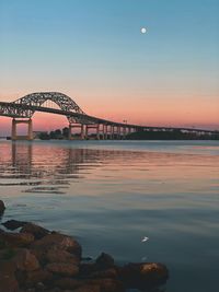 Bridge over river against sky during sunset