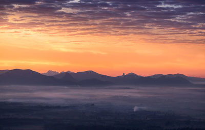 Scenic view of silhouette mountains against romantic sky at sunset