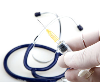 Close-up of hand holding eyeglasses against white background