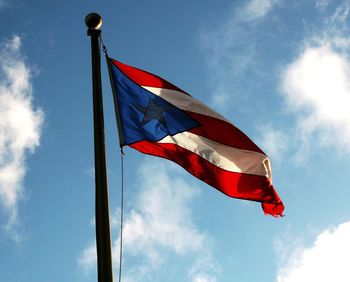 Low angle view of flag against blue sky