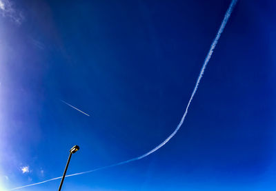 Low angle view of street light against blue sky