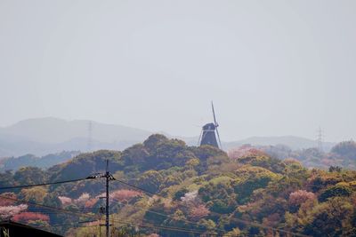 Traditional windmill on mountain against sky