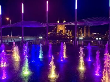 Illuminated fountain in city at night