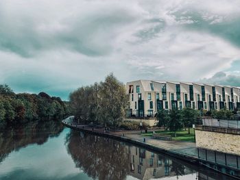 Canal amidst buildings against sky in city