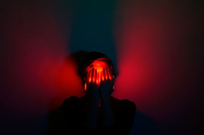 Portrait of person against illuminated wall