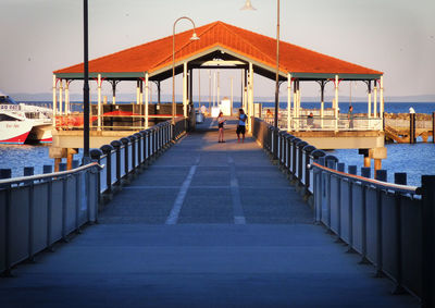 Friends standing on pier over sea