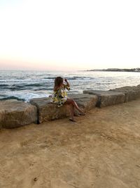 Woman on beach against clear sky