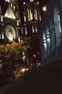 Illuminated street amidst buildings at night