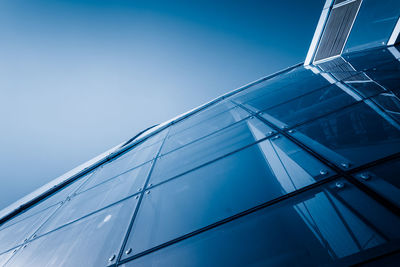 Low angle view of modern building against blue sky