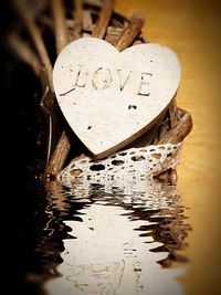 Close-up of heart shape with reflection in water