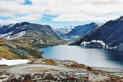 Scenic view of lake and mountains against cloudy sky