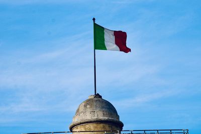 Low angle view of flags against blue sky