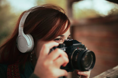 Close-up of woman looking away while photographing with camera