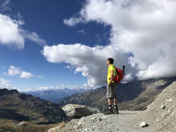 Low angle view of people walking on mountain against sky