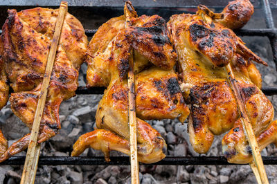 Hot skewer roasting chicken on grilled rack, thai local food