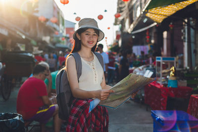 Young woman wearing hat standing in market