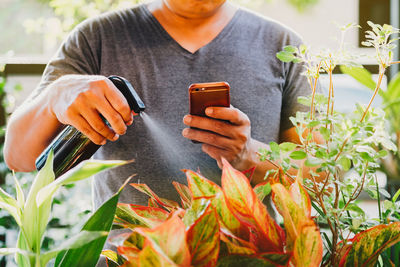 Midsection of man using mobile phone