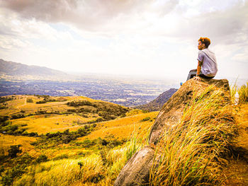 Man looking at mountain against sky