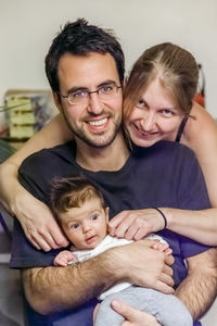 Portrait of parents with cute daughter at home