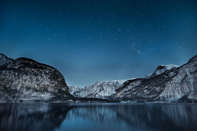 Scenic view of lake and mountains against sky at night