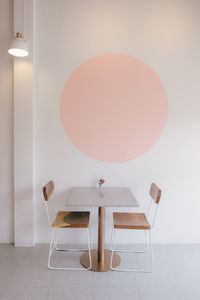 Empty chairs and table against wall at home