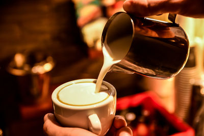 Close-up of woman pouring coffee in cup