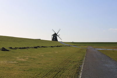 Windmill on field against sky