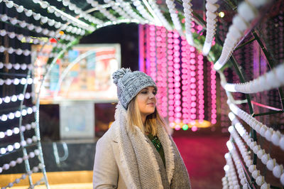 Portrait of young woman looking away at store