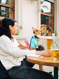 Woman with dog sitting on table