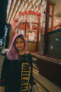 Portrait of young woman standing in train