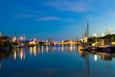 Sailboats in harbor against sky at night