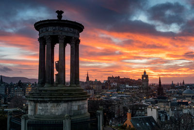 Tower in city against sky during sunset