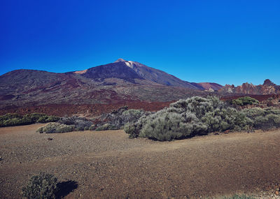 Scenic view of mountains against clear blue sky