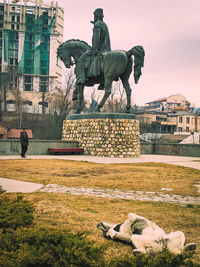 Statue by sea in city
