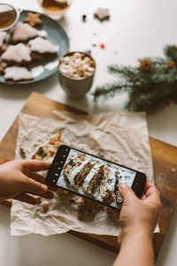 Baker takes a photo of the baked christmas stollen, on a mobile phone