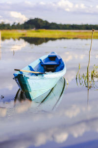 Boat moored on beach against sky