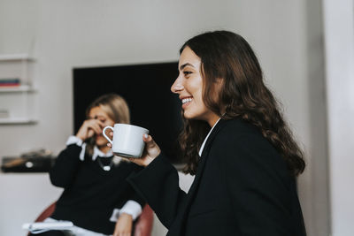 Smiling woman in office during coffee break