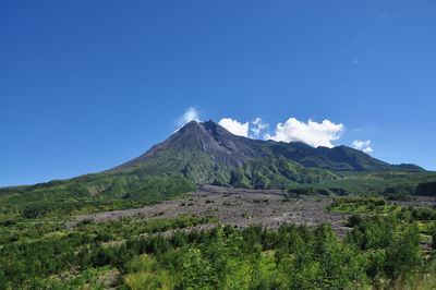 Scenic view of mountains against blue sky