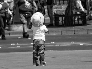 Rear view of boy walking on road