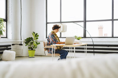 Illustrator working at desk in front of window at office