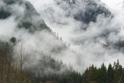 Fog and clouds rolling through snow covered mountains
