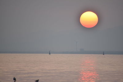 Scenic view of sea against orange sky