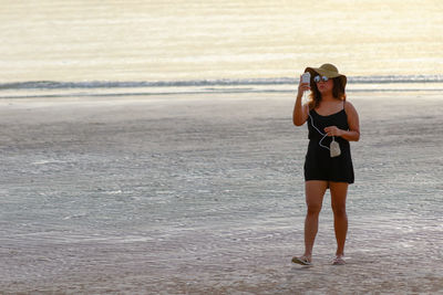 Full length of woman standing on beach